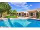 Gorgeous backyard oasis featuring a sparkling pool, lush lawn, and covered patio perfect for outdoor living at 20218 N 61St Ave, Glendale, AZ 85308
