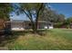 Lush backyard view with mature trees, green grass, view of the house, and privacy landscaping at 2121 S Ventura Dr, Tempe, AZ 85282