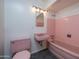 Charming pink bathroom featuring a matching sink, toilet, tub, and pink tiled walls at 2121 S Ventura Dr, Tempe, AZ 85282