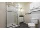 This bathroom features a tiled walk-in shower, vanity and sink with black countertop, white cabinets and tiled floors at 2121 S Ventura Dr, Tempe, AZ 85282