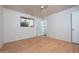 This bright bedroom features laminate floors, neutral walls, a ceiling fan and a door to an ensuite bath at 2121 S Ventura Dr, Tempe, AZ 85282