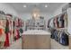 Spacious walk-in closet with ample shelving, clothing racks, and a marble-topped island at 2312 N Raven --, Mesa, AZ 85207