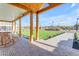 Spacious covered patio featuring brick flooring, wood columns and ample seating with views of landscaped yard at 2312 N Raven --, Mesa, AZ 85207