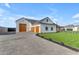 Stunning white farmhouse with wood garage doors and a paved driveway surrounded by manicured landscaping at 2312 N Raven --, Mesa, AZ 85207