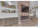 A brick fireplace surround adds warmth and character to this living room with floating shelves at 2312 N Raven --, Mesa, AZ 85207