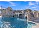 Community pool features a rock waterfall, stairs into the water, and lush landscaping at 2312 N Raven --, Mesa, AZ 85207