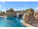 Gorgeous community pool with rock waterfall, lush foliage, and stone stairs for easy access at 2312 N Raven --, Mesa, AZ 85207