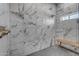The bathroom shower features elegant marble tile and sleek fixtures, complemented by a wooden bench at 2312 N Raven --, Mesa, AZ 85207