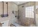 Spa-like bathroom featuring glass-enclosed shower with stone tile and modern fixtures at 2366 E Shea Blvd, Phoenix, AZ 85028