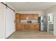 Kitchenette area featuring wood cabinets, granite countertops, stainless steel appliances, and wood flooring at 2366 E Shea Blvd, Phoenix, AZ 85028