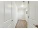 Hallway with wood-style tile floors and white doors creating a clean, modern aesthetic at 24938 S 190Th Dr, Buckeye, AZ 85326
