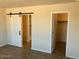 Bedroom with sliding barn door to bath and door to walk in closet at 24938 S 190Th Dr, Buckeye, AZ 85326