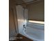 Bathroom featuring a bathtub with shower head, and a window with blinds at 2825 N Villas N Ln, Chandler, AZ 85224