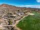 Expansive aerial view showcasing the golf course-adjacent homes with desert landscaping and mountain views at 3045 W Feather Sound Dr, Anthem, AZ 85086