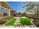 Well-manicured backyard with artificial grass, stone pathway, mature landscaping and an outdoor lounge set at 3045 W Feather Sound Dr, Anthem, AZ 85086