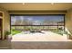 Backyard view of stone pavers, artificial turf, mature trees and BBQ area beyond a retractable shade at 3045 W Feather Sound Dr, Anthem, AZ 85086