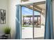 Backyard view through sliding glass doors, showcasing a covered patio with grill and outdoor dining area at 3045 W Feather Sound Dr, Anthem, AZ 85086