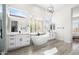 Bright, spacious bathroom featuring a soaking tub, white cabinets, stone counters, and shuttered windows at 3045 W Feather Sound Dr, Anthem, AZ 85086
