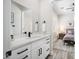 Bright bathroom featuring white cabinets, stone counters, black hardware and fixtures, and access to bedroom at 3045 W Feather Sound Dr, Anthem, AZ 85086