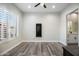 Neutral bedroom with sleek ceiling fan, wood-look floors, and plenty of natural light at 3045 W Feather Sound Dr, Anthem, AZ 85086