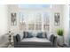 Bedroom sitting area with a sofa and shuttered windows offering natural light and decorative wall art at 3045 W Feather Sound Dr, Anthem, AZ 85086