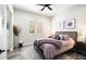 Bedroom showcasing shuttered windows, wood-look tile floors, a ceiling fan, and a plush gray area rug at 3045 W Feather Sound Dr, Anthem, AZ 85086