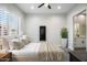 Stylized bedroom featuring wood-look floors, a ceiling fan, and an ensuite bathroom at 3045 W Feather Sound Dr, Anthem, AZ 85086