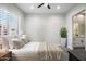 Stylized bedroom featuring wood-look floors, a ceiling fan, and an ensuite bathroom at 3045 W Feather Sound Dr, Anthem, AZ 85086