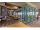 Elegant dining room with a large glass wine display, modern lighting, and desert views at 3045 W Feather Sound Dr, Anthem, AZ 85086