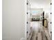 Hallway featuring wood-look tile floors and views into a spacious living room with shuttered windows at 3045 W Feather Sound Dr, Anthem, AZ 85086