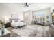 Spacious main bedroom with wood-look tile floors, a ceiling fan, and large windows with shutters at 3045 W Feather Sound Dr, Anthem, AZ 85086