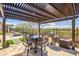 Large covered patio featuring an outdoor kitchen with built-in grill and a built-in seating area at 3045 W Feather Sound Dr, Anthem, AZ 85086