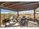 Cozy outdoor kitchen with grill, BBQ, bar-height dining set, and covered patio with view at 3045 W Feather Sound Dr, Anthem, AZ 85086