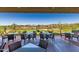 Outdoor patio with tables and seating overlooking a lush green golf course and desert landscape at 3045 W Feather Sound Dr, Anthem, AZ 85086