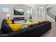 Bright living room with modern fireplace, large screen TV, and gray sofa with yellow pillows at 3875 E Appaloosa Rd, Gilbert, AZ 85296