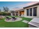 Spacious backyard featuring a built-in barbecue, covered patio, and desert landscaping at 42001 N Bridlewood Way, Phoenix, AZ 85086