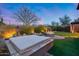 Inviting backyard with a covered hot tub, lounge area, and a tranquil waterfall feature at 42001 N Bridlewood Way, Phoenix, AZ 85086