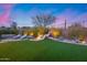 Wide view of a beautifully landscaped backyard with waterfall feature, hot tub, and patio at 42001 N Bridlewood Way, Phoenix, AZ 85086