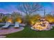 Beautiful backyard featuring a waterfall, manicured landscaping, and two lounge chairs at 42001 N Bridlewood Way, Phoenix, AZ 85086