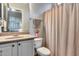Cozy bathroom with a single sink vanity, toilet, and shower with a pink shower curtain at 42001 N Bridlewood Way, Phoenix, AZ 85086