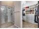Walk in closet with custom shelving and storage adjacent to a walk in glass surround shower at 42001 N Bridlewood Way, Phoenix, AZ 85086