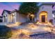 Well-lit walkway leading to a welcoming front door, complemented by desert landscaping and a three-car garage at 42001 N Bridlewood Way, Phoenix, AZ 85086