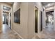 Hallway features decorative wall art, neutral paint, tile floors and multiple doorways throughout the home at 42001 N Bridlewood Way, Phoenix, AZ 85086