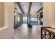 Open-concept living space with tiled floors, wooden beams, elegant chandeliers, and access to outdoor patio at 42001 N Bridlewood Way, Phoenix, AZ 85086
