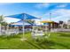 Inviting outdoor seating area with picnic tables and shade structures on a well-maintained lawn at 42001 N Bridlewood Way, Phoenix, AZ 85086