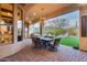 Covered outdoor patio featuring a chandelier, dining set, and overlooking the green backyard at 42001 N Bridlewood Way, Phoenix, AZ 85086