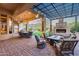 Expansive covered patio boasts multiple seating areas, an outdoor kitchen, and backyard views at 42001 N Bridlewood Way, Phoenix, AZ 85086
