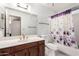 Bathroom featuring vanity with storage, large mirror, and shower with purple floral curtain at 4401 E Walatowa St, Phoenix, AZ 85044