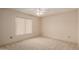 This bright bedroom features neutral carpet, a ceiling fan and a window at 4401 E Walatowa St, Phoenix, AZ 85044
