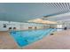 Well-lit indoor swimming pool with skylights, accessible entrance ramp, and safety equipment at 4401 E Walatowa St, Phoenix, AZ 85044
